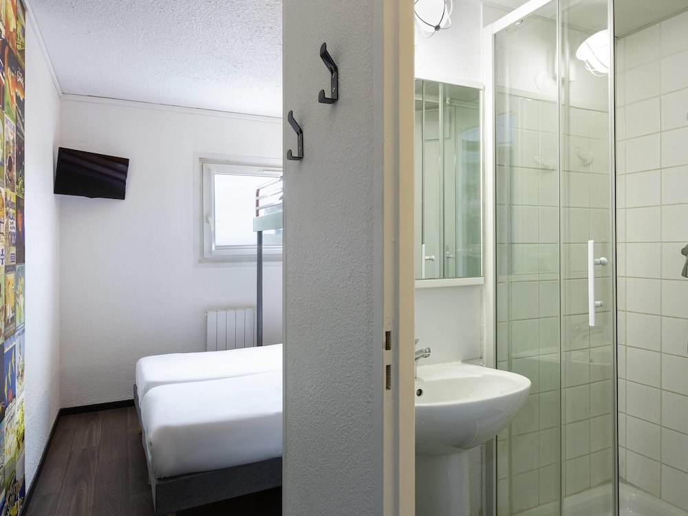 Habitación con 2 camas individuales y baño del hotel F1 Reims Tinqueux. Foto 1