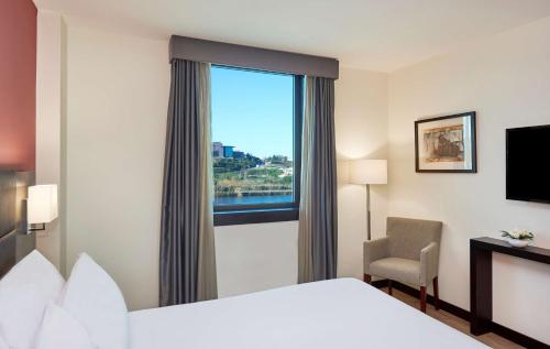 Habitación Estándar con vistas al río y cama supletoria del hotel NH Coimbra Dona Inês. Foto 3