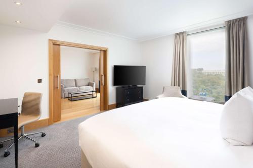 Suite con cama extragrande y salón del hotel Hilton London Gatwick Airport. Foto 5