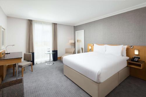 Suite con cama extragrande y salón del hotel Hilton London Gatwick Airport. Foto 7