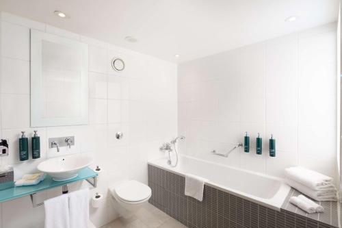 Suite con cama extragrande y salón del hotel Hilton London Gatwick Airport. Foto 11