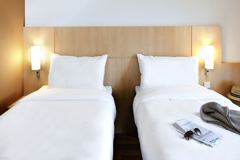 Habitación con 2 camas individuales equipada con la nueva ropa de cama del hotel Ibis Lyon Est Chaponnay. Foto 1