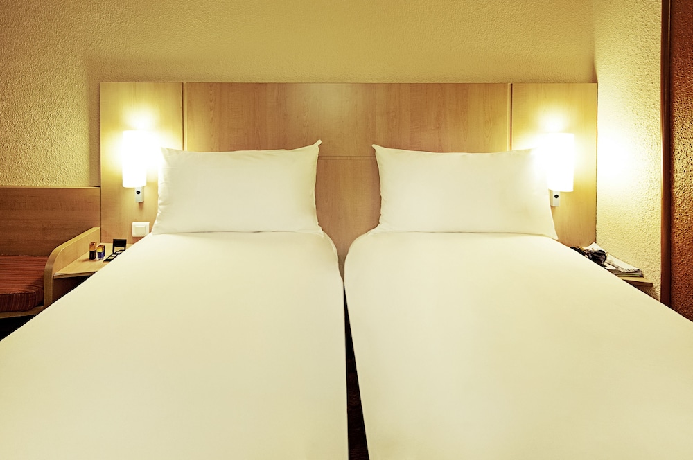 Habitación con 2 camas individuales equipada con la nueva ropa de cama del hotel Ibis Lyon Est Chaponnay. Foto 2