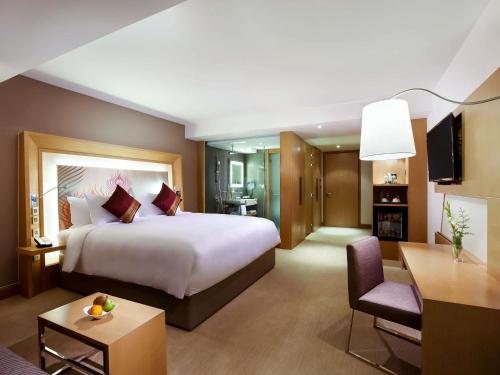 Habitación Deluxe con sofá y cama extragrande del hotel Novotel Yangon Max. Foto 1
