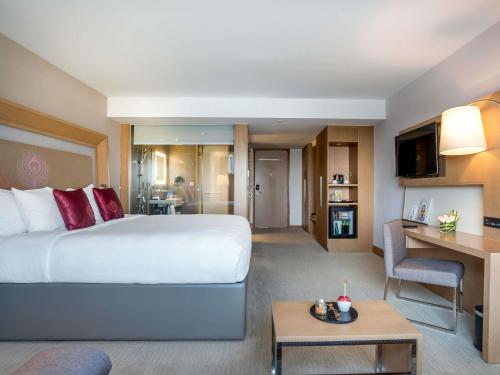 Habitación Deluxe con sofá y cama extragrande del hotel Novotel Yangon Max. Foto 8