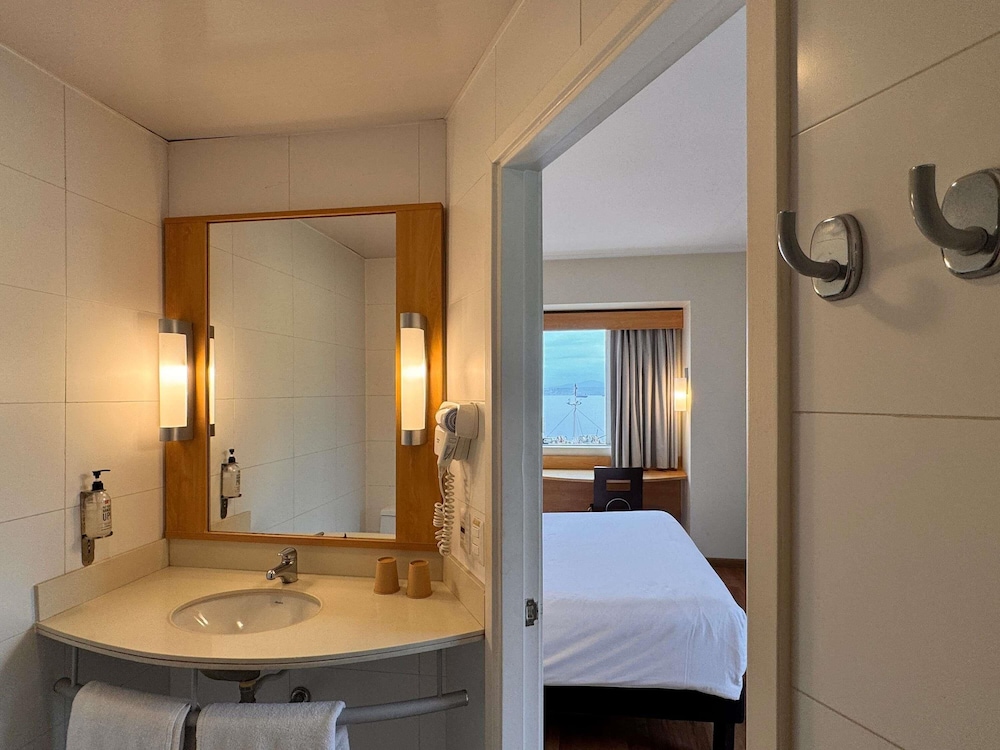 Habitacion con una cama queen size para dos personas y vista al mar del hotel Ibis Valparaiso. Foto 7