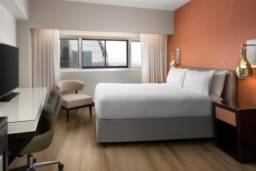 Habitación con cama grande y vistas a la ciudad del hotel Millennium Hilton New York One UN Plaza. Foto 4