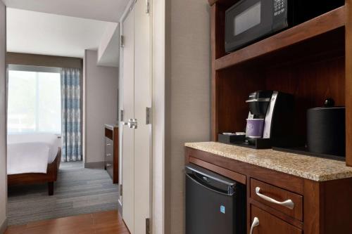 Suite Junior adaptada para personas con discapacidad auditiva - Cama extragrande del hotel Hilton Garden Inn Stony Brook
