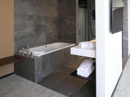 Suite Junior con 1 cama king size, bañera de hidromasaje, acceso a la terraza y vistas al río del hotel Mercure Namur. Foto 2