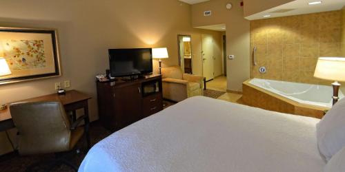Habitación con cama extragrande y bañera de hidromasaje del hotel Hampton Inn Geneseo. Foto 1