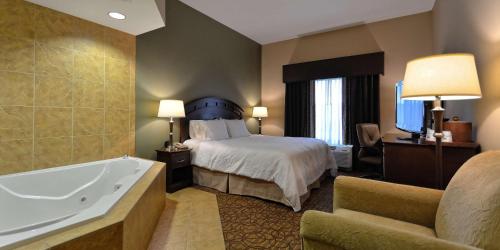Habitación con cama extragrande y bañera de hidromasaje del hotel Hampton Inn Geneseo. Foto 3