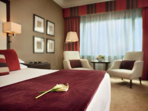 Habitación Executive con cama extragrande y acceso al salón del hotel Mövenpick Grand Al Bustan Dubai. Foto 1