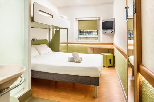 Habitación triple con cama grande y litera superior. del hotel Ibis Budget Bergerac. Foto 7