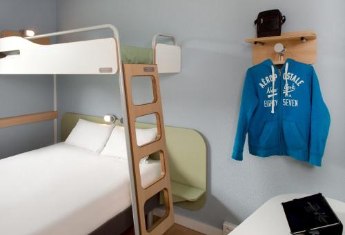 Habitación triple con cama grande y litera superior. del hotel Ibis Budget Bergerac. Foto 9