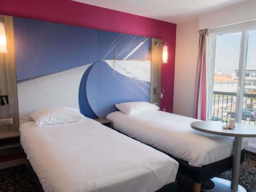 Suite familiar Standard con cama doble y dos camas individuales del hotel Ibis Styles Saint Gilles Croix De Vie. Foto 1