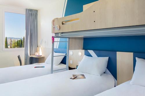 Habitación Standard familiar con 3 camas individuales y 1 cama superpuesta del hotel Ibis budget Valence Nord Plateau des Couleures. Foto 11