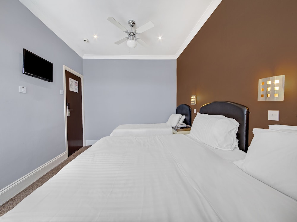 Habitación triple estándar, varias camas del hotel Oyo Bostons Manor. Foto 3