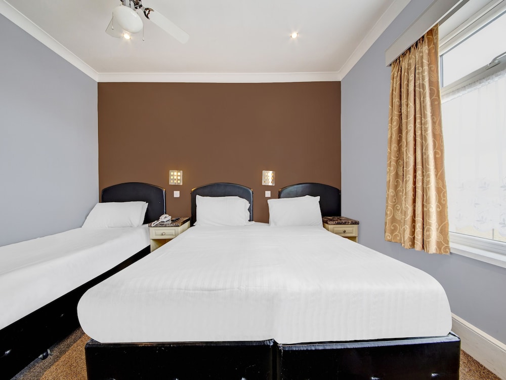Habitación triple estándar, varias camas del hotel Oyo Bostons Manor. Foto 4