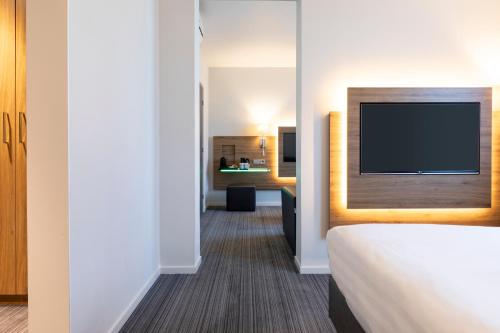 Habitación Familiar Moxyfied Sleeper con 1 cama grande y sofá cama del hotel Moxy London Excel. Foto 1