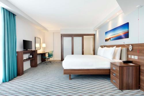 Habitación adaptada para personas de movilidad reducida con vistas a la pista - Cama grande del hotel Hampton By Hilton London Stansted Airport. Foto 1