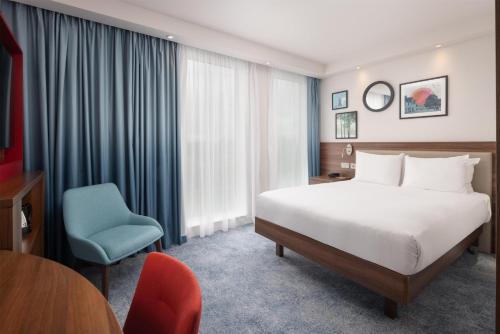 Habitación con cama grande y bañera del hotel Hampton By Hilton London Stansted Airport. Foto 7
