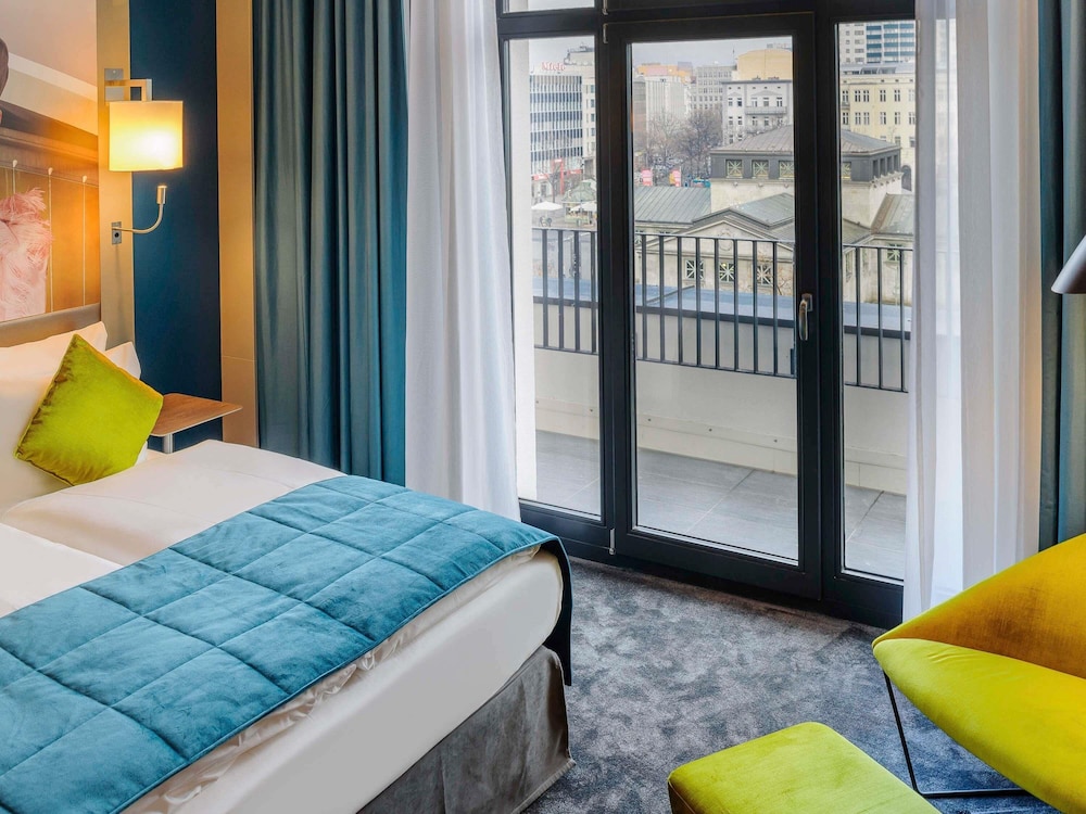 Habitación con balcón y cama queen size del hotel Mercure Hotel Berlin Wittenbergplatz