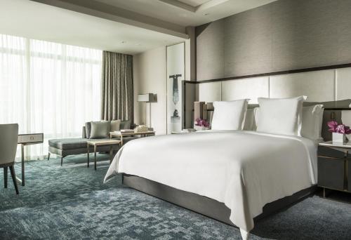 Habitación con cama extragrande y vistas a la piscina y al jardín del hotel Four Seasons Kuala Lumpur. Foto 1