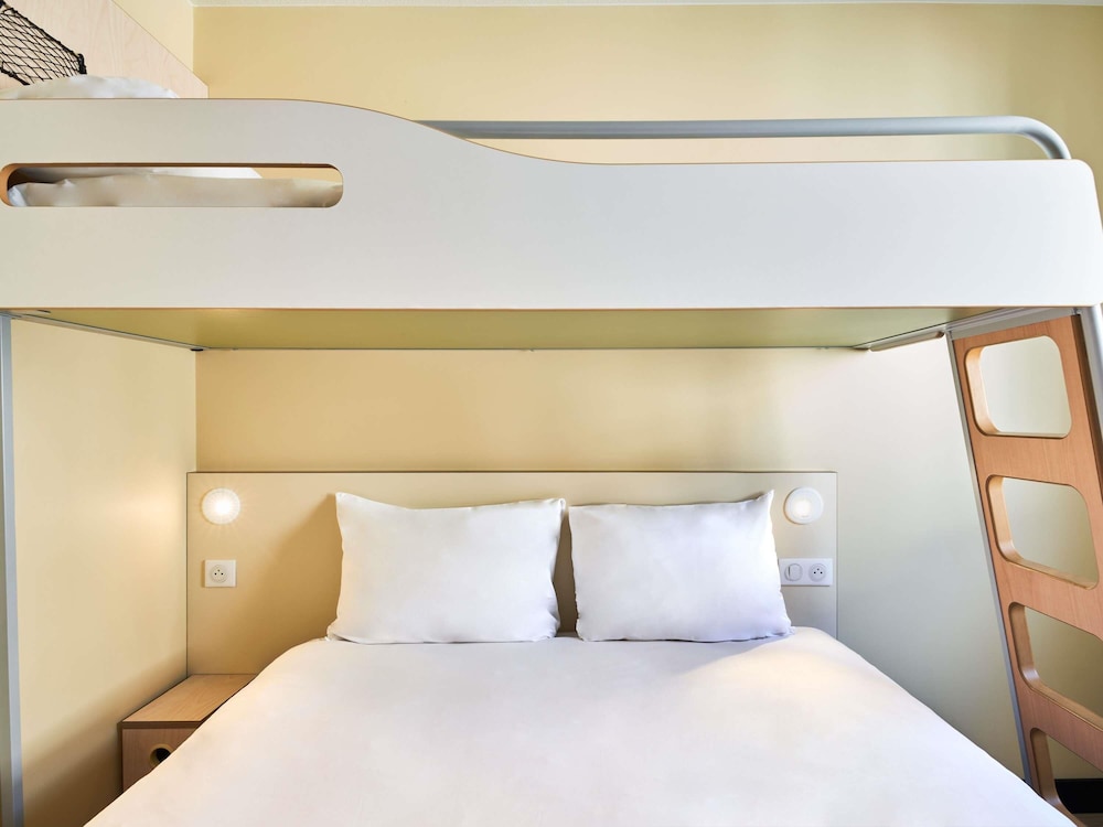 Habitación con una cama grande y una litera del hotel Ibis Budget Saint Maurice