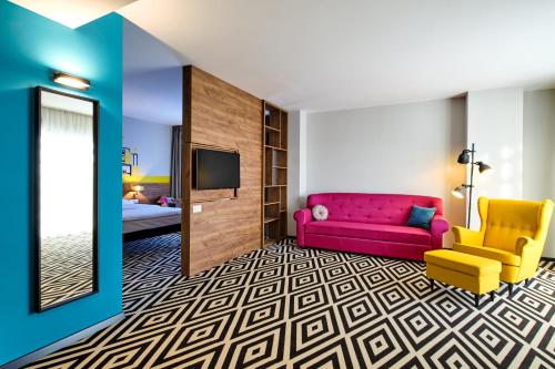 Amplio apartamento con salón y dormitorio con 1 cama doble y 1 sofá del hotel Ibis Styles Arad. Foto 3