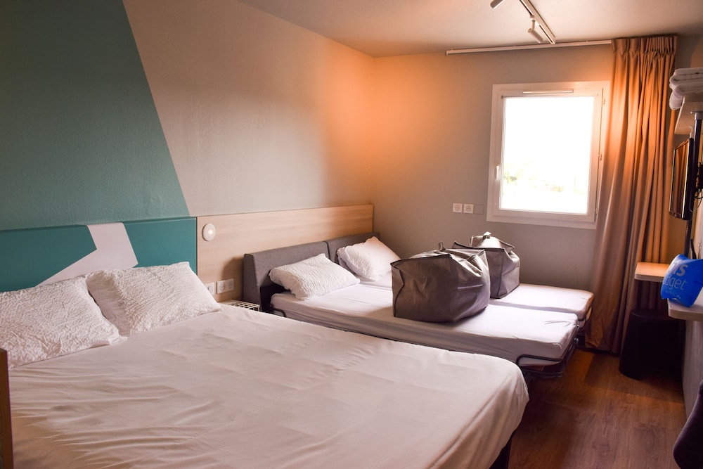 Habitación familiar con 1 cama doble y 2 camas individuales del hotel Ibis Budget Millau Viaduc. Foto 1