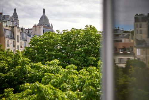 Habitación Triple Superior con balcón y vistas a la Torre Eiffel y al Sacre Coeur del hotel Timhotel Montmartre. Foto 5