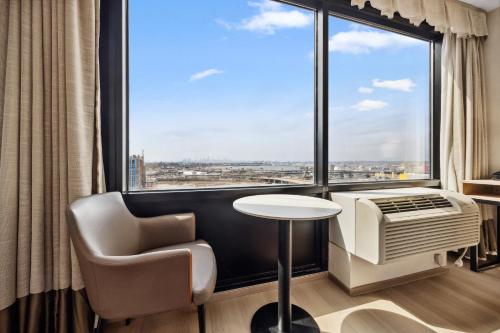 Habitación adaptada para personas con discapacidad y equipada con ducha accesible en silla de ruedas - Cama extragrande del hotel Ramada Flushing Queens. Foto 1