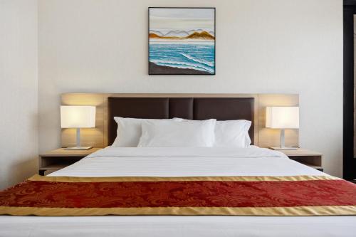 Habitación adaptada para personas con discapacidad y equipada con ducha accesible en silla de ruedas - Cama extragrande del hotel Ramada Flushing Queens. Foto 2