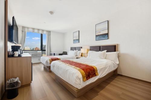 Habitación Doble Estándar con 2 camas dobles del hotel Ramada Flushing Queens. Foto 7