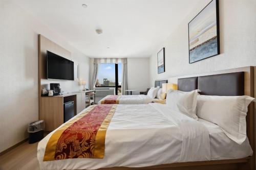Habitación Doble para no fumadores con 2 camas dobles y bañera del hotel Ramada Flushing Queens. Foto 1