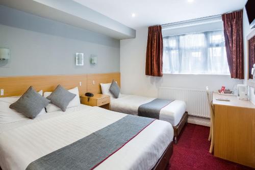 Habitación Triple Deluxe del hotel OYO London Guest House. Foto 1