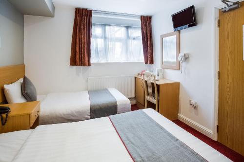Habitación Triple Deluxe del hotel OYO London Guest House. Foto 4