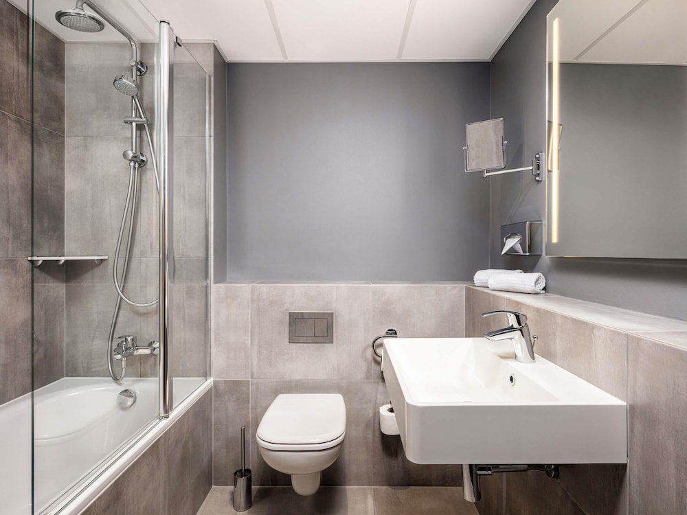 Moderna y elegante habitación de categoría superior con una cama de gran tamaño y sofá del hotel Novotel Poznan Centrum