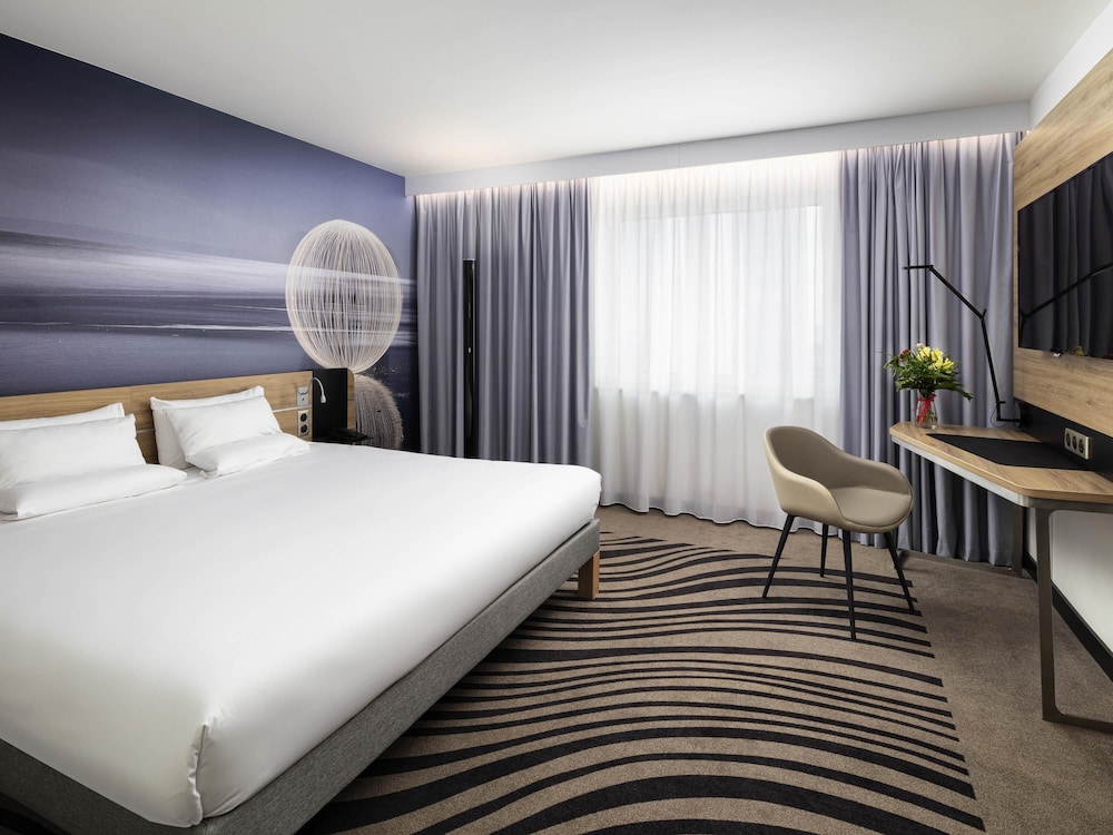 Moderna y elegante habitación de categoría superior con una cama de gran tamaño del hotel Novotel Poznan Centrum. Foto 3