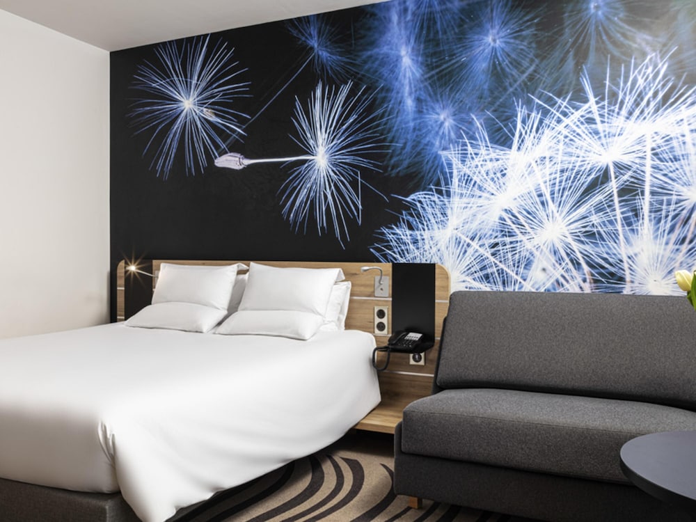 Moderna y elegante habitación de categoría superior con una cama de gran tamaño y sofá del hotel Novotel Poznan Centrum. Foto 2