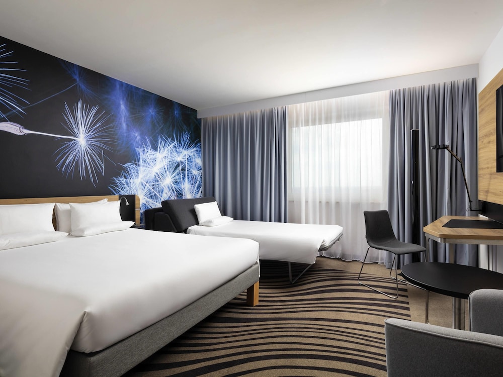 Moderna y elegante habitación de categoría superior con una cama de gran tamaño y sofá del hotel Novotel Poznan Centrum. Foto 3