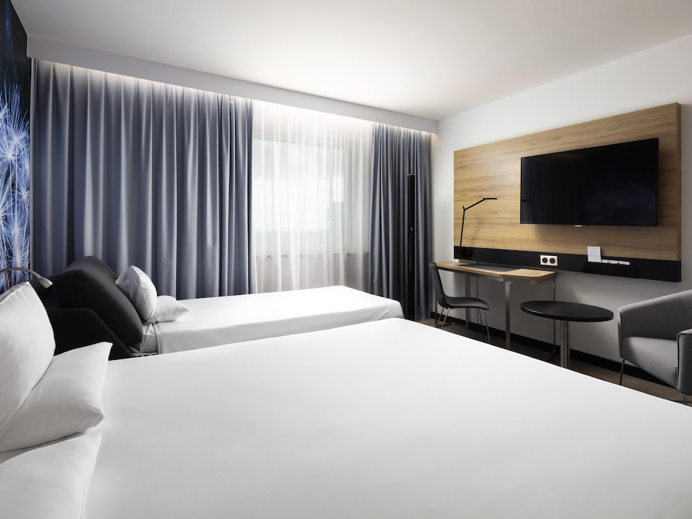 Moderna y elegante habitación de categoría superior con una cama de gran tamaño y sofá del hotel Novotel Poznan Centrum. Foto 5