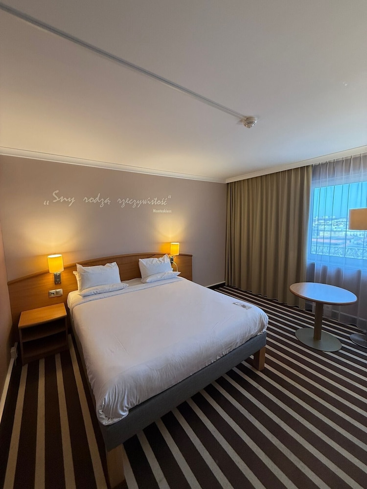 Confortable y amplia habitación con una cama de gran tamaño del hotel Novotel Poznan Centrum. Foto 2