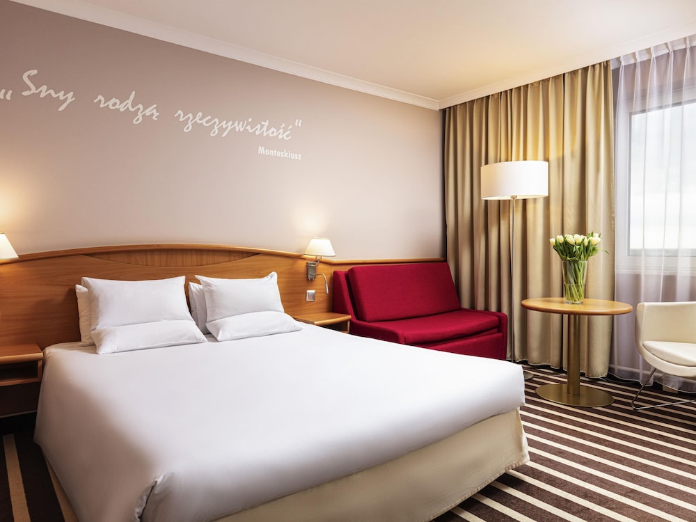 Confortable y amplia habitación con una cama de gran tamaño del hotel Novotel Poznan Centrum. Foto 5