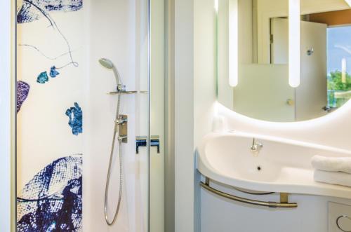 Habitación Triple - 2 camas individuales y litera del hotel Ibis Budget Saint Quentin En Yvelines Velodrome. Foto 3