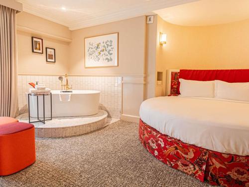 Suite Luna de Miel con cama redonda, bañera, zona de salón y vistas al Grand Boulevard del hotel Sofitel Le Scribe Paris Opéra. Foto 2