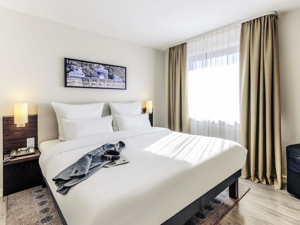 Suite Privilege con cama king size y sofá del hotel Mercure München Süd Messe