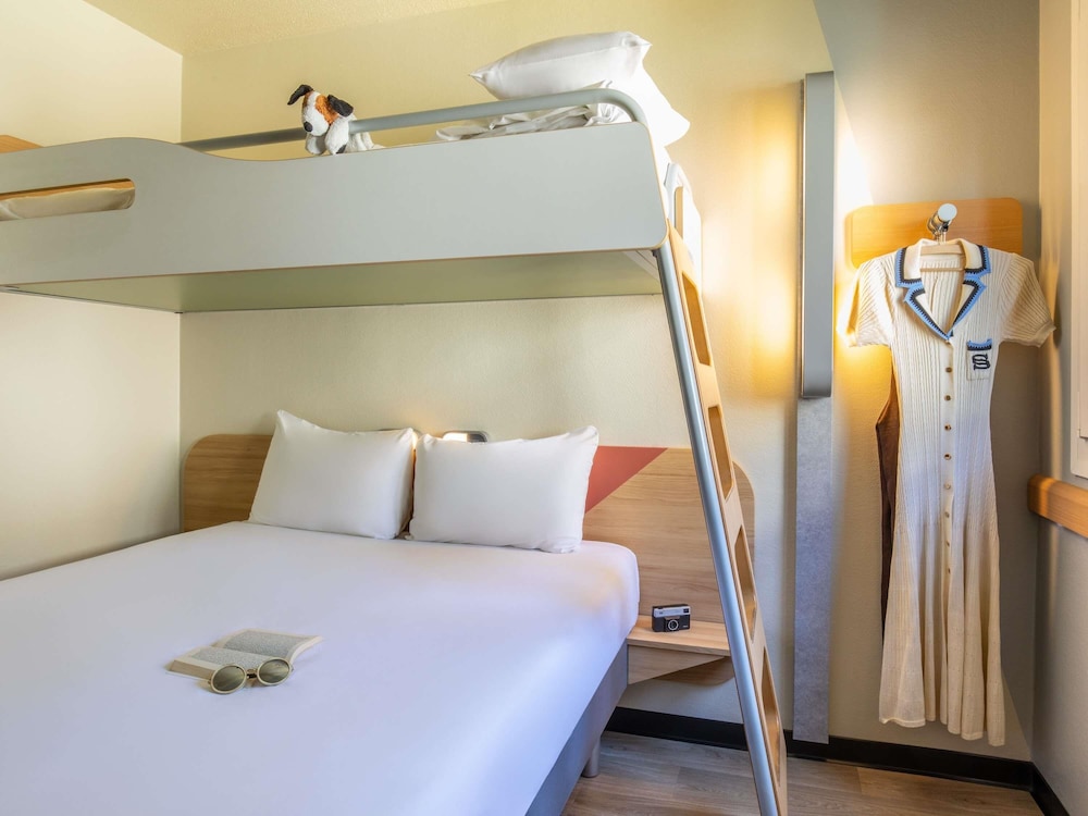 Habitación con una cama grande y una litera del hotel Ibis Budget Marne La Vallée