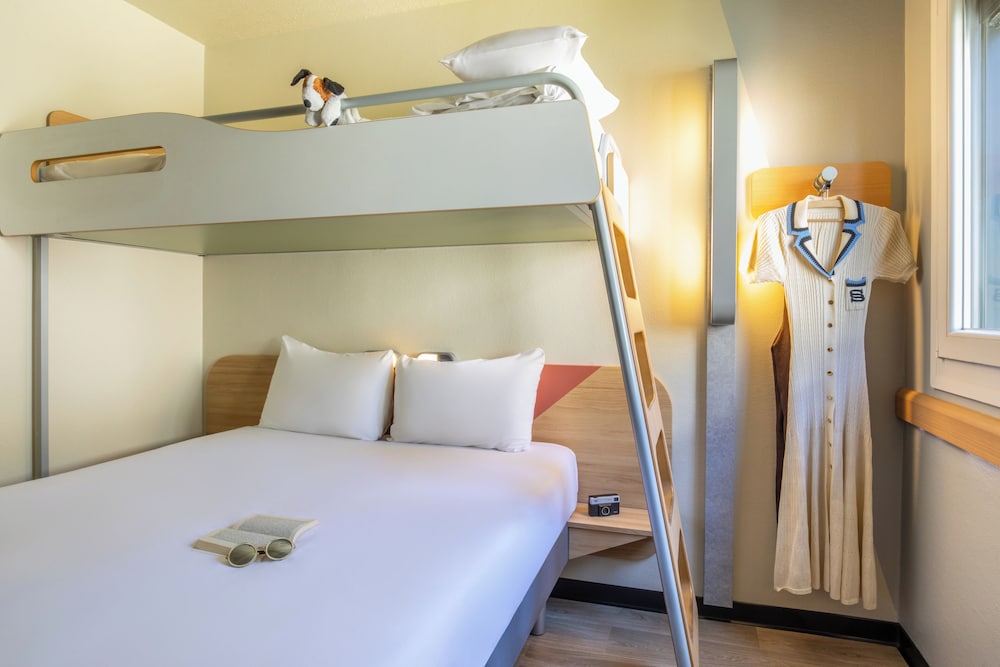 Habitación con una cama grande y una litera del hotel Ibis Budget Marne La Vallée. Foto 1