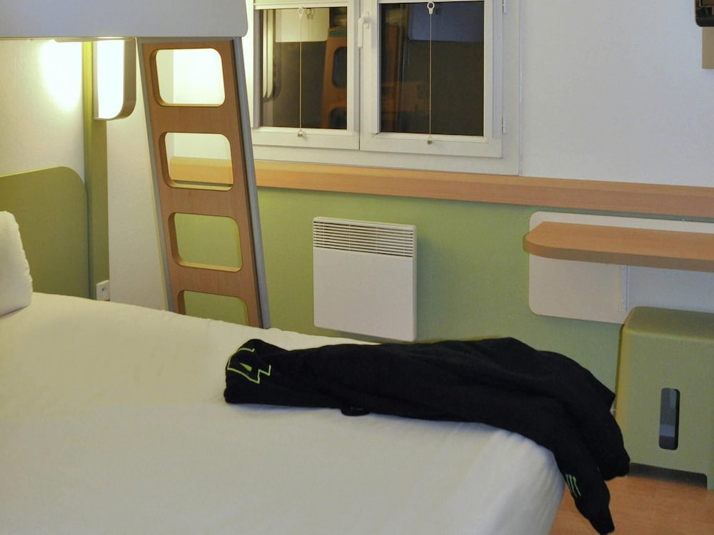 Habitación con una cama grande y una litera del hotel Ibis Budget Marne La Vallée